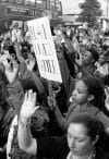 Black Lives Matter protesters kneel and raise their hands in London's Oxford Street on July 8, 2016