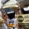 Protesters shouting slogans for migrant workers' rights outside an employment agency in Hong Kong last year. One in three households with children in Hong Kong employs a foreign domestic worker, who works an average of over 70 hours a week