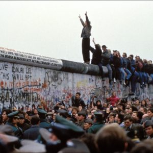 BERLIN, GERMANY - NOVEMBER 12: A man celebrates on the Berlin wall on November 12, 1989 in Berlin, Germany.(Photo by Pool CHUTE DU MUR BERLIN/Gamma-Rapho via Getty Images)