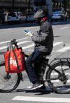 A Grubhub delivery person checks his phone during the coronavirus pandemic on May 3, 2020 in New York City.